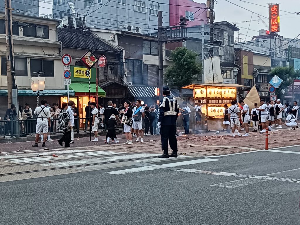 One Night a Year, Firecrackers Take Over the Streets: Nagasaki's Shoro Nagashi A police officer directing traffic along the spirit boats' route