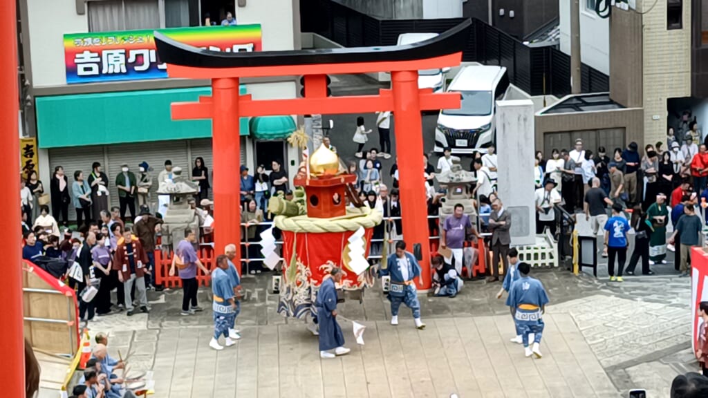 Aburaya-machi's kasaboko being carried in front of a torii gate at Yasaka Shrine during Niizoroi, watched by a crowd
