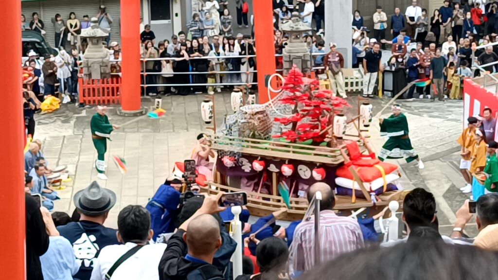 Aburaya-machi's kawafune float tilting as men in blue costumes spin it during Niizoroi at Yasaka Shrine